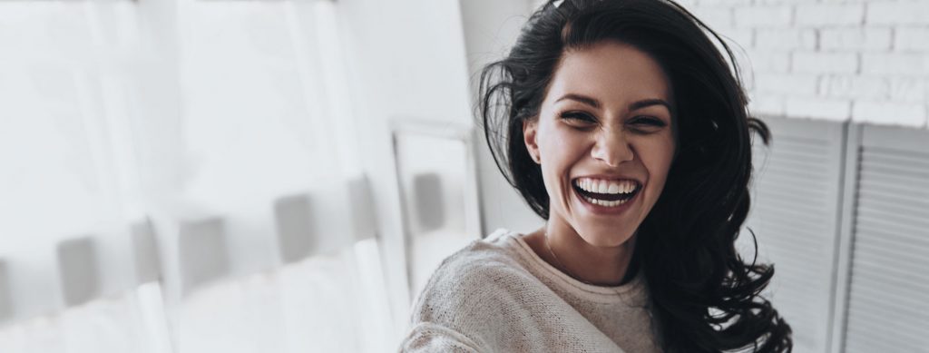 A young woman smiling with a white background behind her